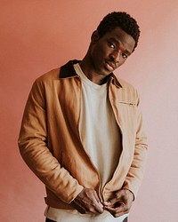 Black man in brown jacket mockup on pink background studio shot