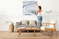 Woman arranging frame on a wall in a Scandinavian living room