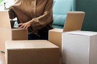 Woman unpacking kraft boxes in the living room