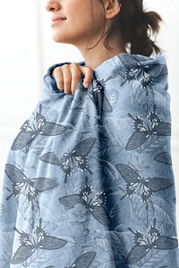 Woman wrapped around with blue butterfly patterned throw blanket in winter