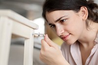 Woman screwing in chair’s nail for ready-to-assemble furniture