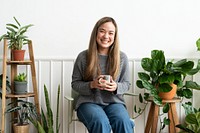 Plant lady resting and sipping team in her plant corner