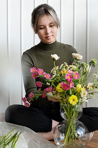 Woman arranging flowers into a vase
