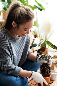 Woman repotting a houseplant inside of her house