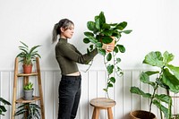 Happy woman carrying a houseplant