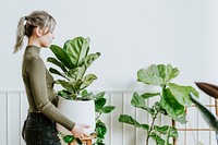 Happy woman carrying a houseplant