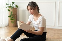 Woman reading a book sitting on a floor