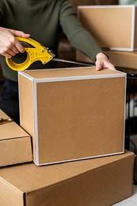 Small business owner packing product parcel boxes for delivery