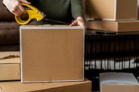 Small business owner packing product parcel boxes for delivery