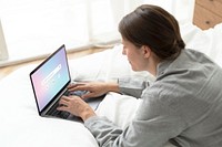 Businesswoman working from home in her bed