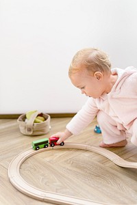 Toddler playing with a wooden toy train