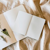 Two open notebook psd mockup and flowers on linen blanket