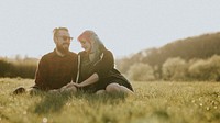 Couple sitting together on the field