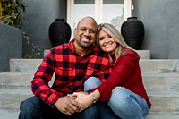 Happy married couple holding hands on the front porch