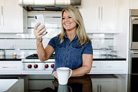 Woman using a mobile phone in the kitchen