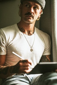 Hipster man in white tee using digital tablet