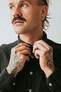Alternative tattooed man in button up black shirt