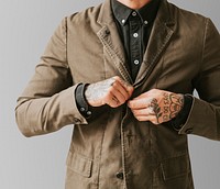 Man with tattooed hands buttoning his jacket. 2 OCTOBER 2020 - CHIPPENHAM, UK