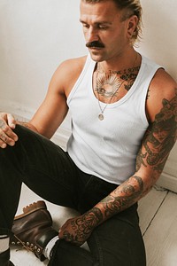 Handsome man in white tank top and black pants studio shot