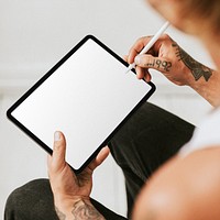 Tattooed man working on tablet screen mockup