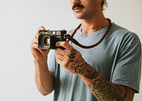Photographer with tattoos shooting with a film camera