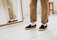 Urban man in beige pants standing in front of the mirror