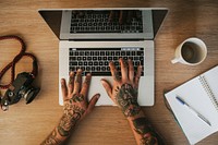 Tattooed alternative man using a laptop