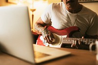 Alternative man playing the electric guitar in a studio