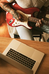 Alternative man playing the electric guitar in a studio