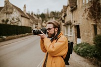 Photographer man taking photos in the village in Cotswolds, UK