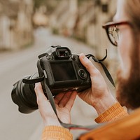 Photographer man viewing his photos on the camera 