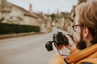 Photographer man viewing his photos on the camera