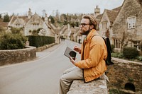 Man taking notes on his tablet in the village