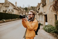 Photographer man taking photos in the village in Cotswolds, UK