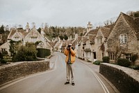 Photographer man taking photos in the village Cotswolds, UK