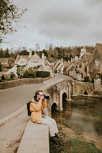 Photographer man taking photos in the village in Cotswolds, UK