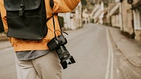 DSLR camera with strap hanging on photographer’s shoulder