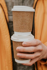 Recycled coffee cups mockup psd with hand closeup