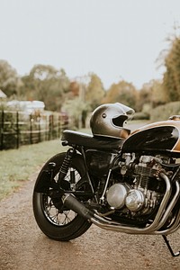 Vintage motorbike and helmet parked in countryside
