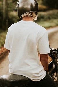 Blonde man in white t-shirt sitting on a bike with design space