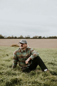 Urban man in a cap chilling on the grass field