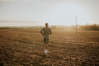 Active man in sportswear running in the countryside