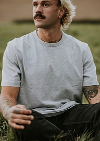 Attractive man in gray t-shirt with design space in countryside