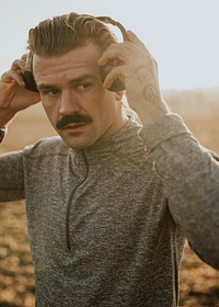 Cool man listening to music wearing wireless headphones