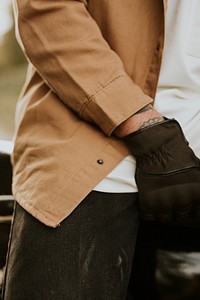 Man in brown jacket white tee and biker glove closeup