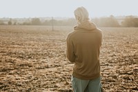 Man in stretchy hoodie in the countryside at sunset