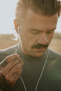 Cool urban man listening to music while working out