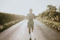 Man in stretch shirt running in the countryside at sunset