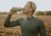 Man drinking water from stainless steel bottle after working out