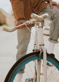 Tattooed hand holding onto bike’s handlebar closeup